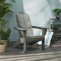 Grey POLYWOOD Vineyard Curveback Adirondack Chair arranged on an outdoor patio alongside potted plants and decor.