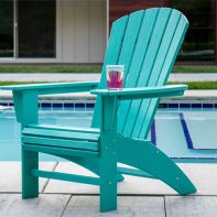 Teal POLYWOOD® Nautical Curveback Adirondack Chair arranged poolside on a stone patio with a drink resting on the wide armrest.
