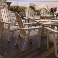 POLYWOOD® Vineyard Curveback Adirondack Dining Chairs arranged around an outdoor dining table set for a patio dinner on a deck.