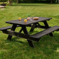 Dark grey POLYWOOD® Park 72" Picnic Table with attached benches and refreshments on a green lawn in an outdoor park setting.