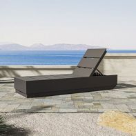 Modern dark grey POLYWOOD® Elevate Chaise Lounge with an adjustable backrest placed on a stone patio overlooking a scenic coastal ocean view.