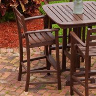 POLYWOOD Lakeside Bar Arm Chair paired with an outdoor bar table on a brick patio for commercial alfresco dining.